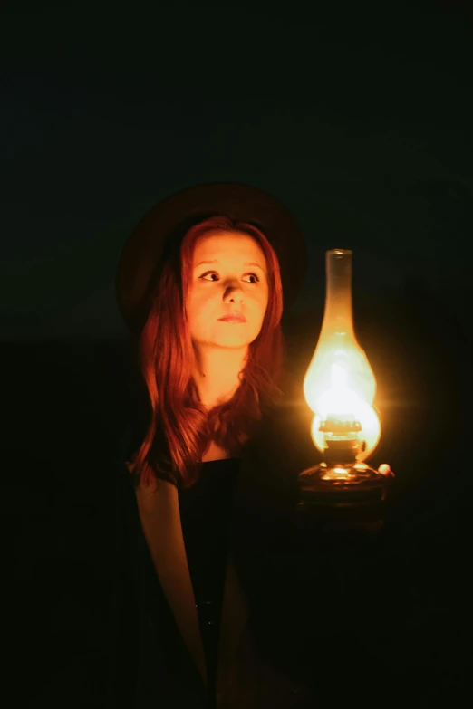 a woman holding a lit bottle with a glow