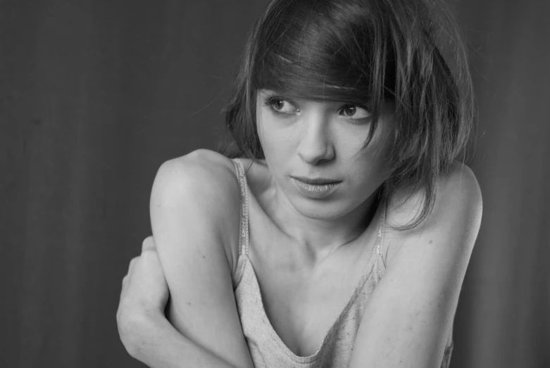 a women in grey dress looking at the camera