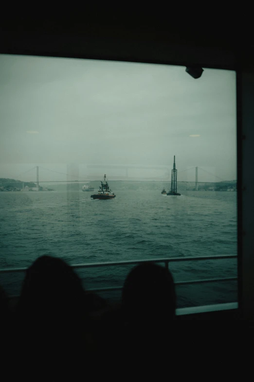 a boat is passing in the water as people are watching