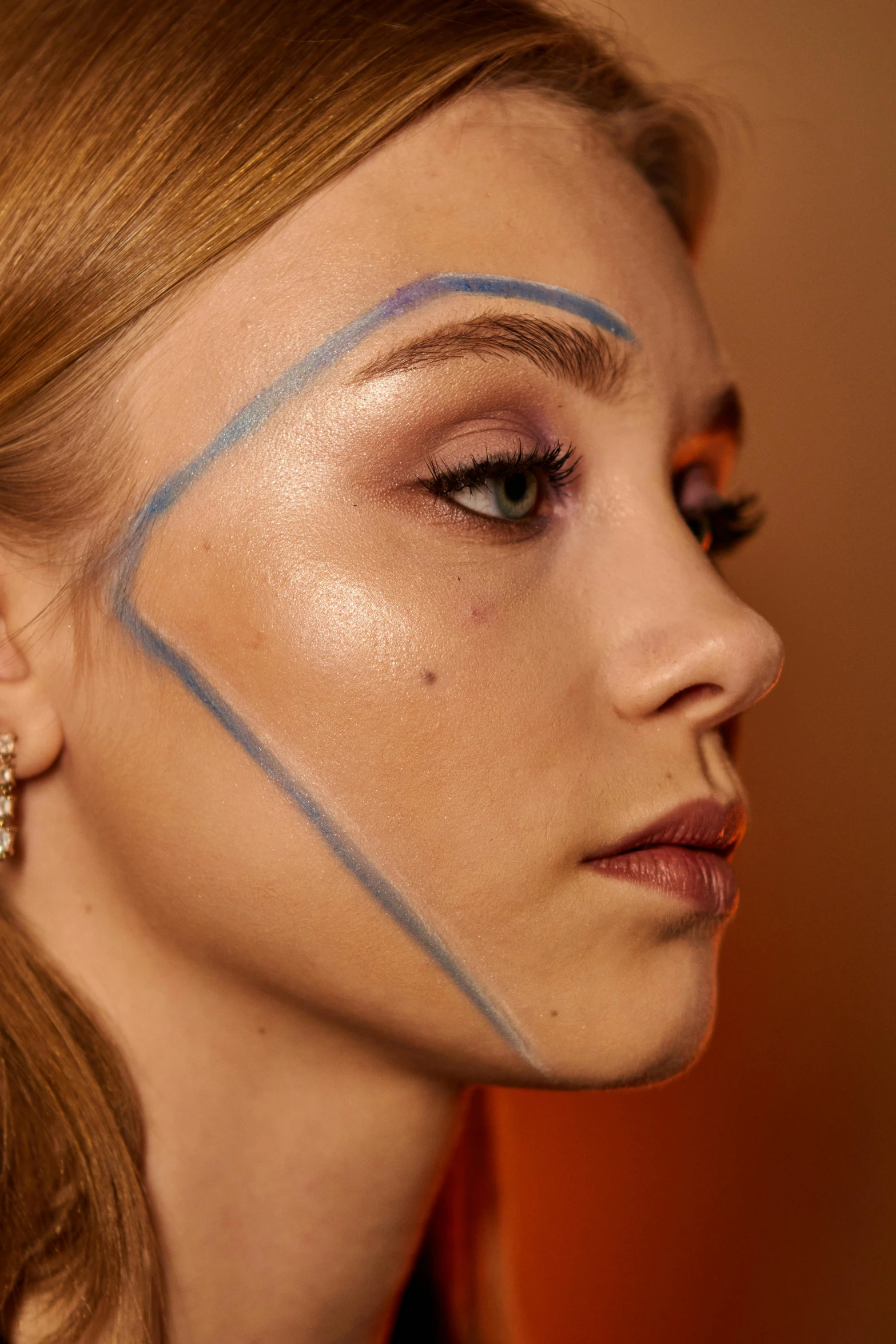 a woman with makeup has her face painted blue