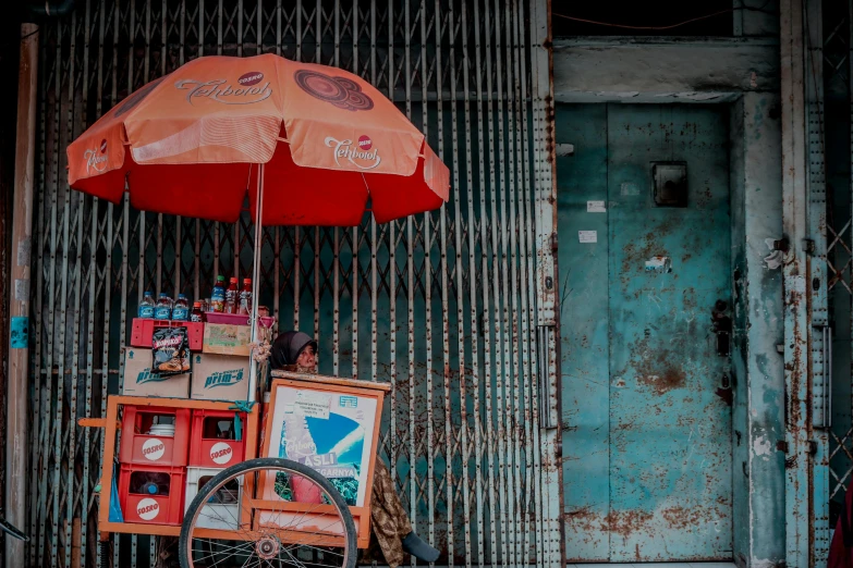 an umbrella over a wall covered in signs and pos