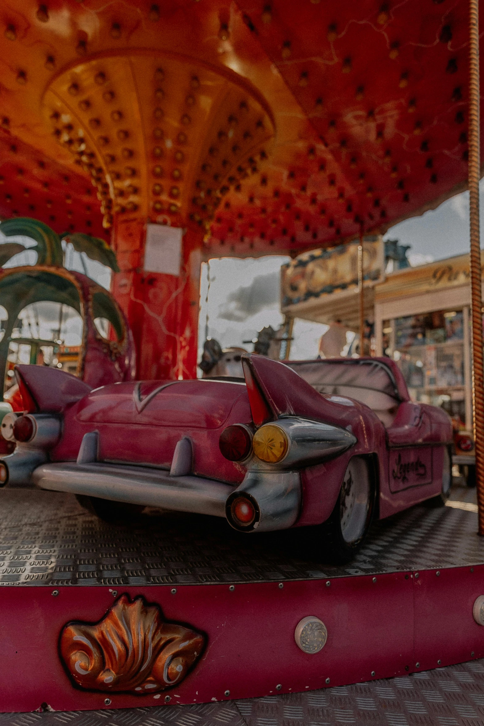 a carnival ride with classic pink car and carnival rides
