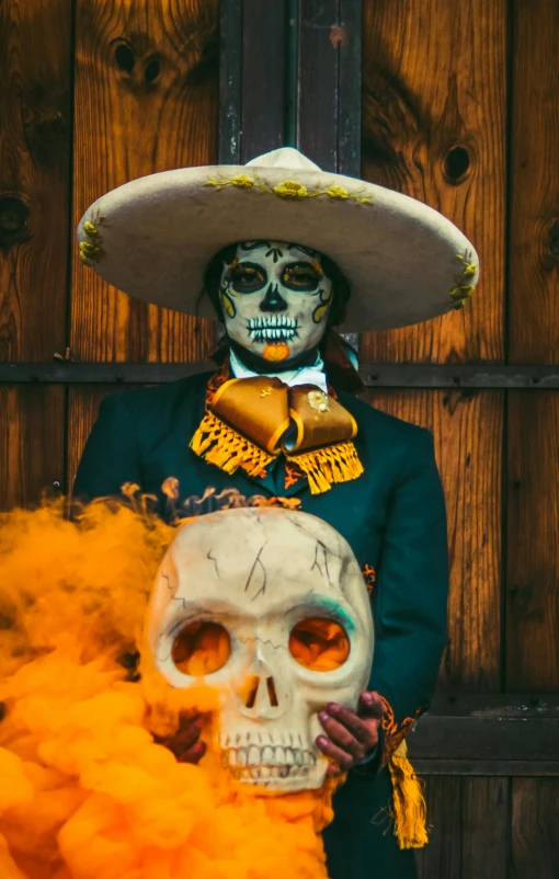 a mexican skeleton in a mexican hat holds a pipe