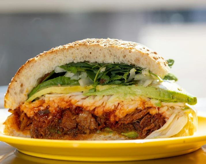 a sandwich filled with meat and green onions sitting on a yellow plate