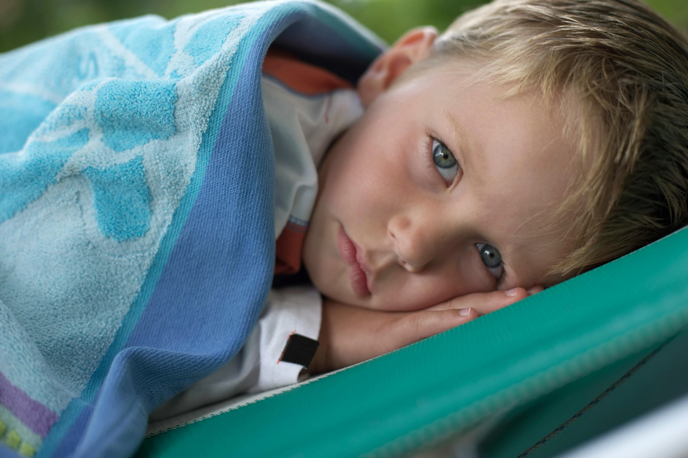 a  is holding a towel and snuggling his eyes