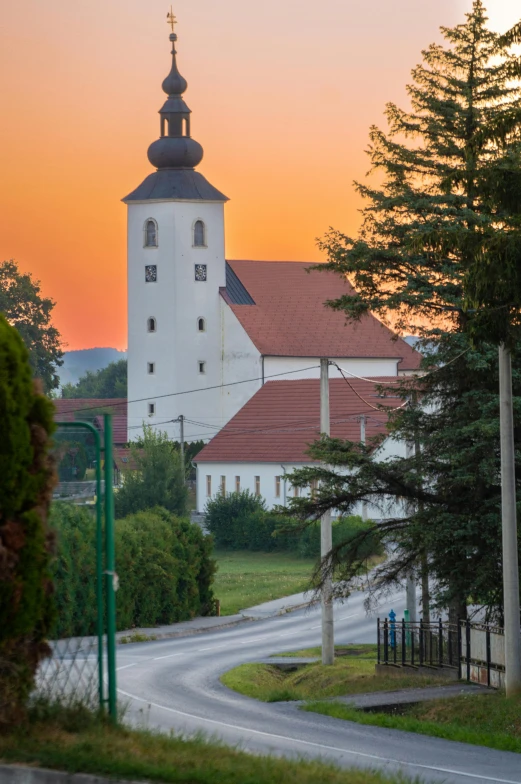 the house is white with red roof and a steeple