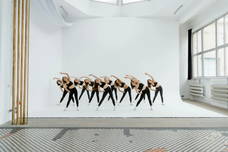 a group of woman dancing on top of a white wall