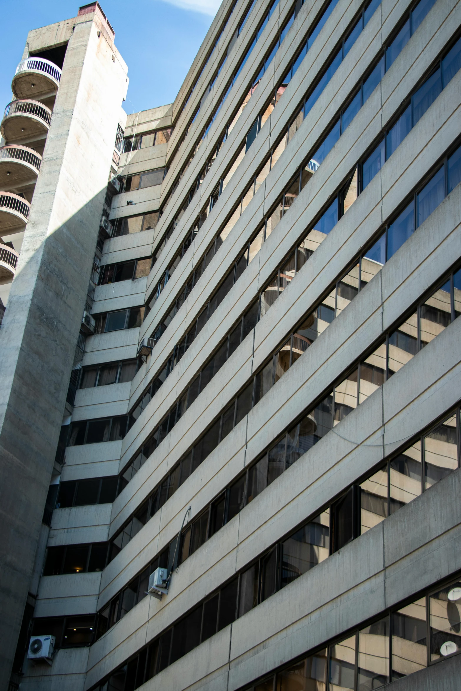 the front of a large grey building with tall windows