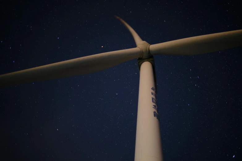 a po taken looking up at the bottom of a white wind turbine