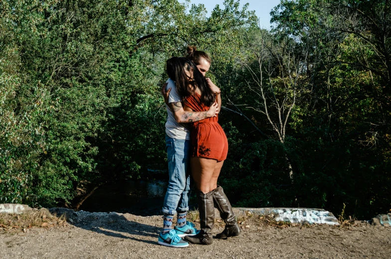 couple in love emcing while standing on a road in between trees