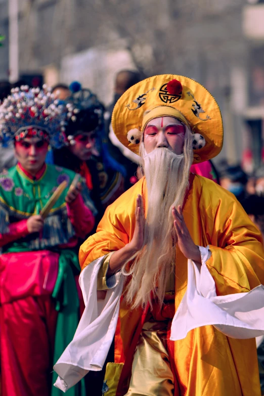 a man with an long beard wearing a large yellow hat and yellow and white headgear