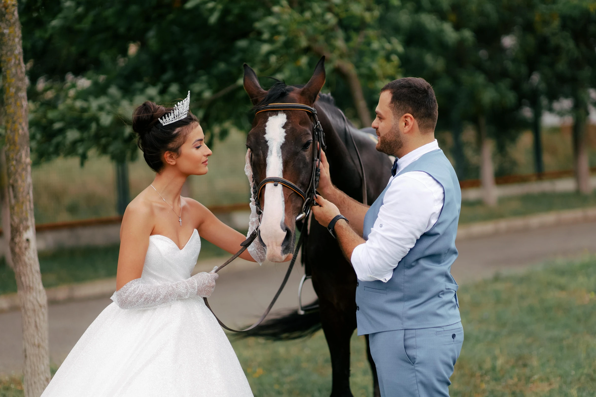 a bride and groom standing beside a horse