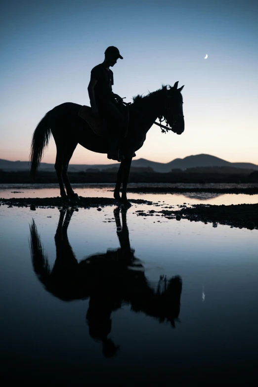 person sitting on a horse near a body of water