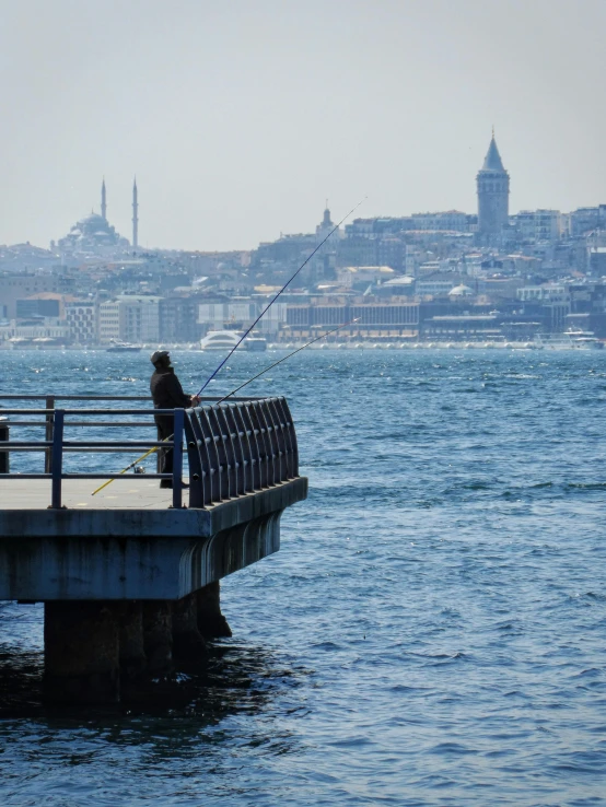 a man standing on top of a bridge next to the ocean