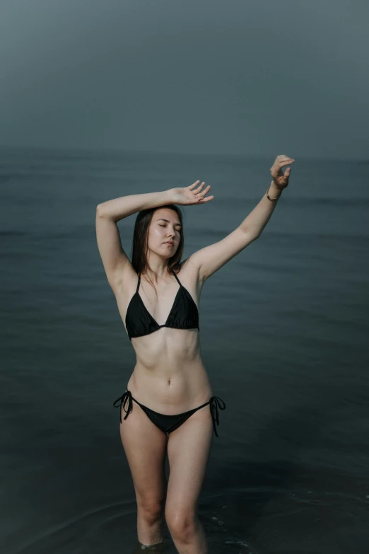 a woman in a bikini standing in the ocean