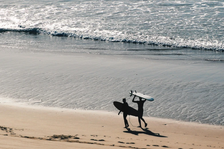 a person standing on a beach holding a surfboard