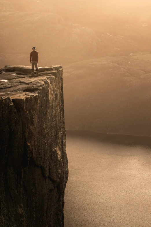 a person standing on a rock looking over a cliff