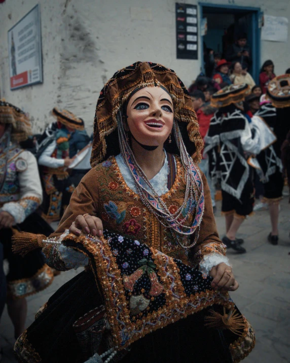 woman in brown and black ethnic dress with white nose ring, people in background