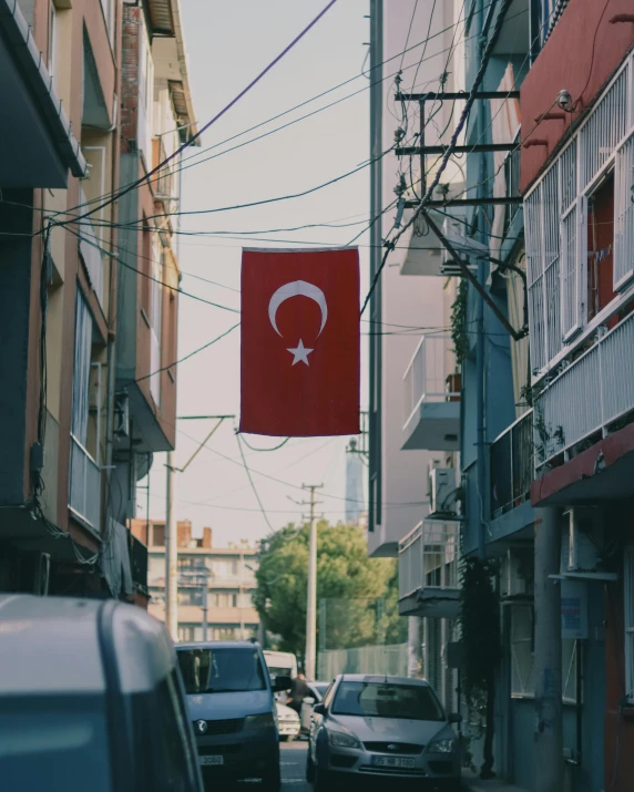 a red sign hanging from a wire over a street