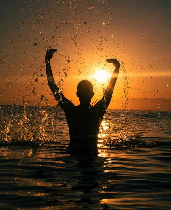 a person in the water getting ready to see the sun set