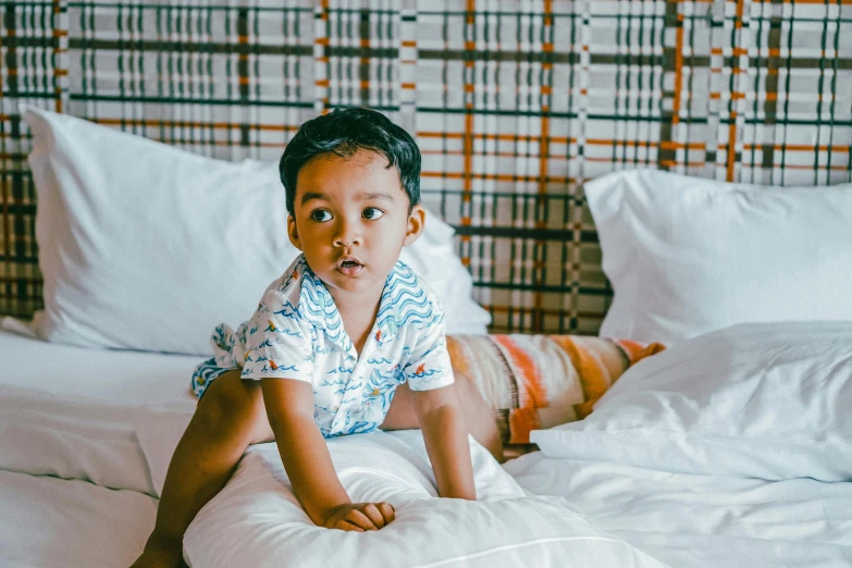 a  is lying on a white bed and looking up