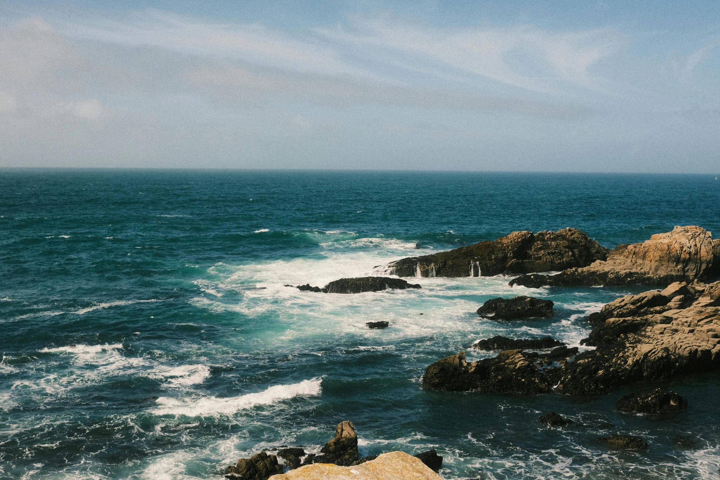 the view of rocks and ocean from an overlook point