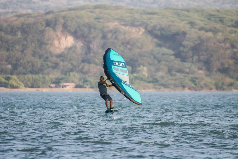 there is a man windsurfing on a body of water