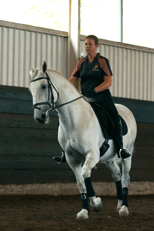 a woman riding on the back of a white horse