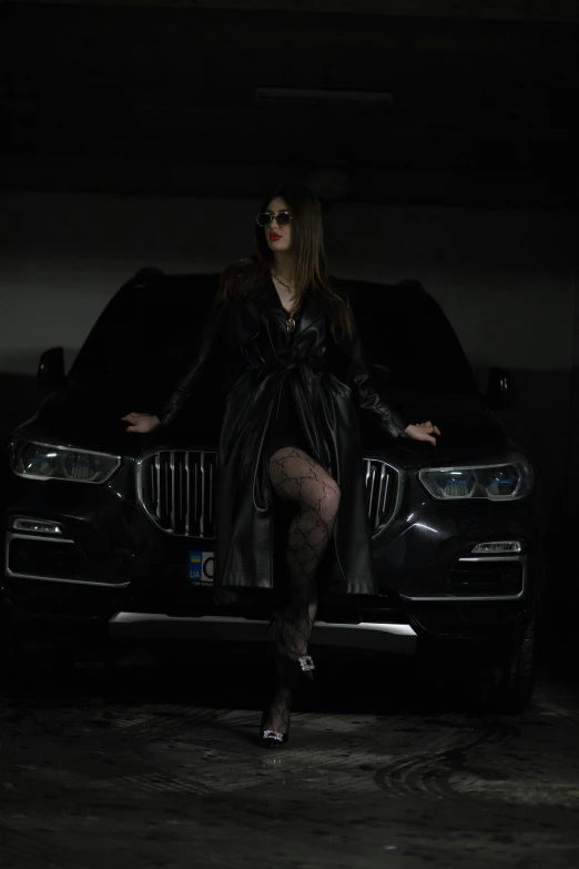 a woman in a dress is standing next to a car