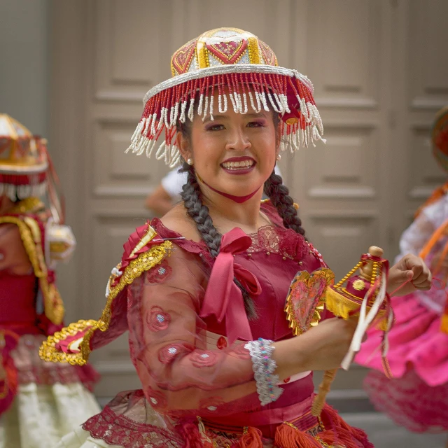 a group of little girls dressed in red performing