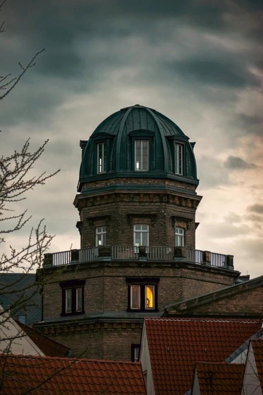 a building has a green domed structure with a light in the window