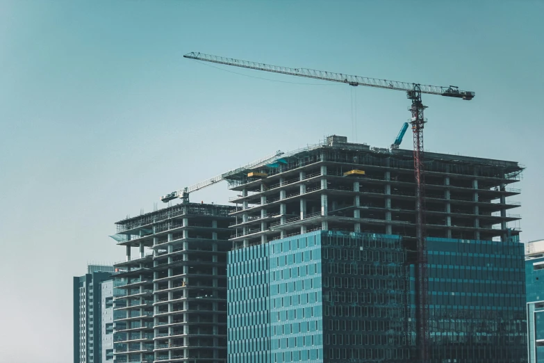 a tall building with two crane's on it