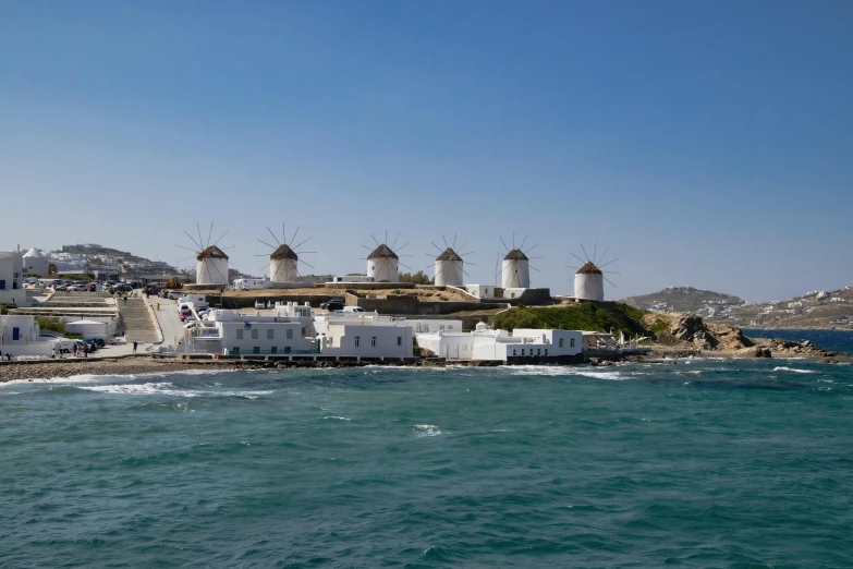 there are some buildings on the shore of the ocean