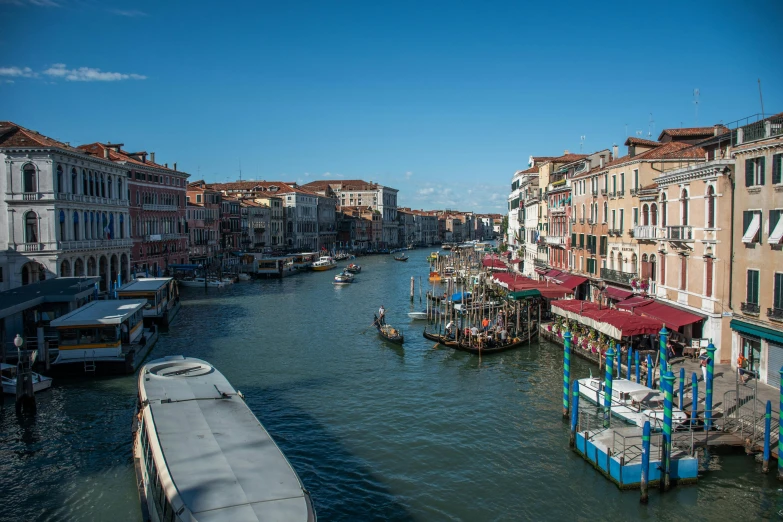 many boats traveling through the narrow canals near a city