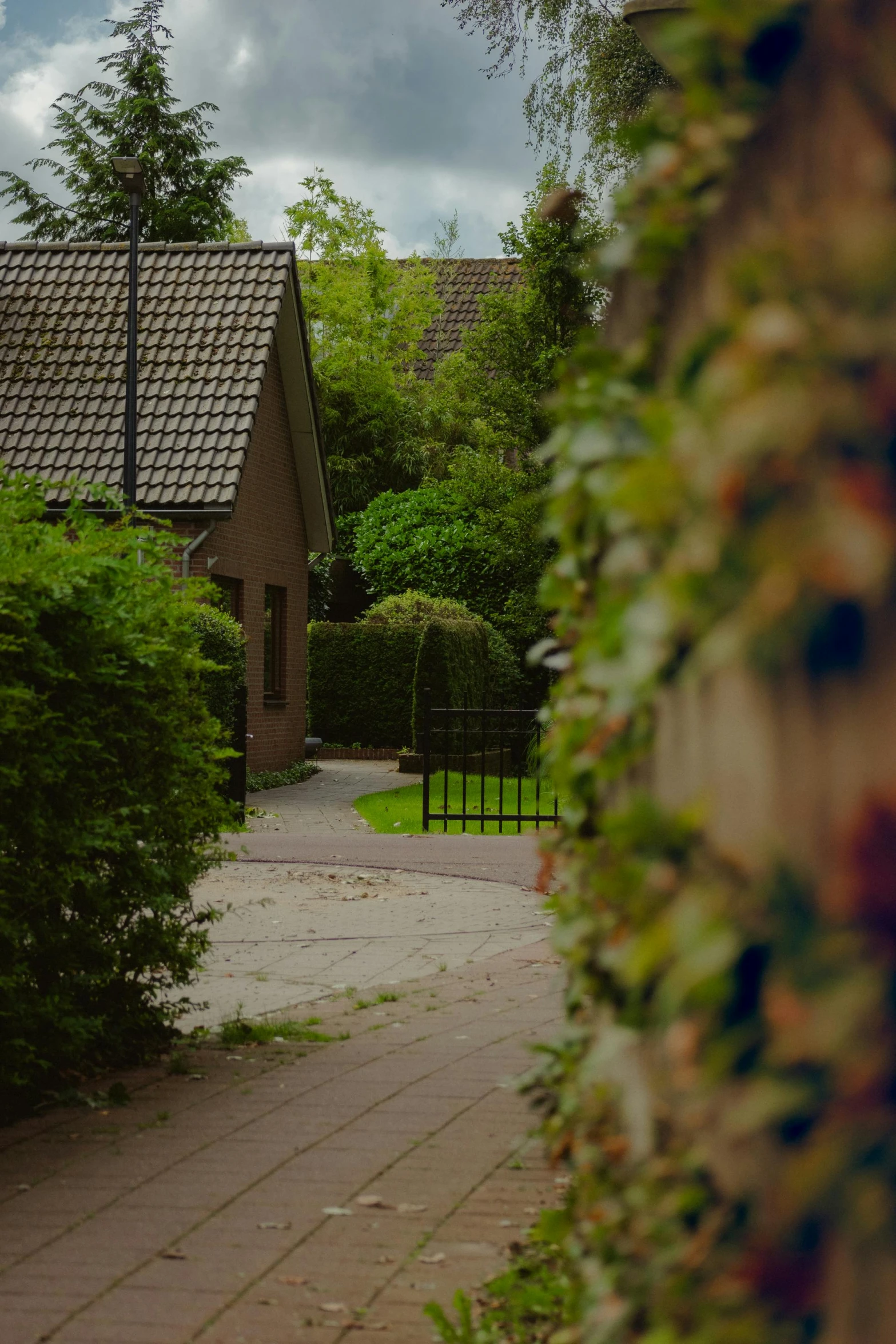 the driveway of a small house with a gate