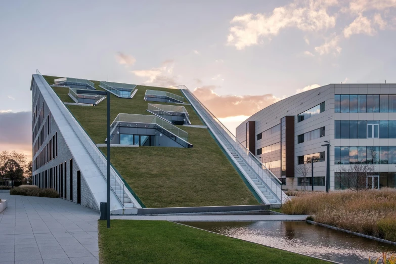 large modern building with green roof and water canal