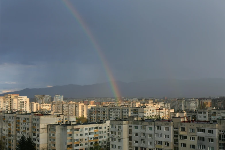 a rainbow above a city filled with tall buildings