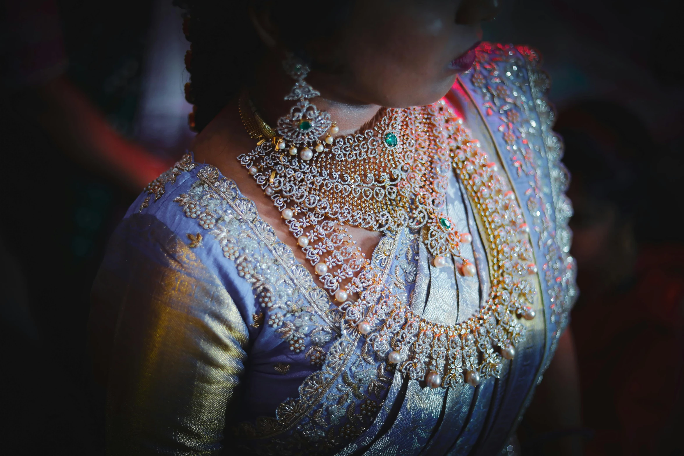 a close up view of a woman wearing a necklace and jewelry