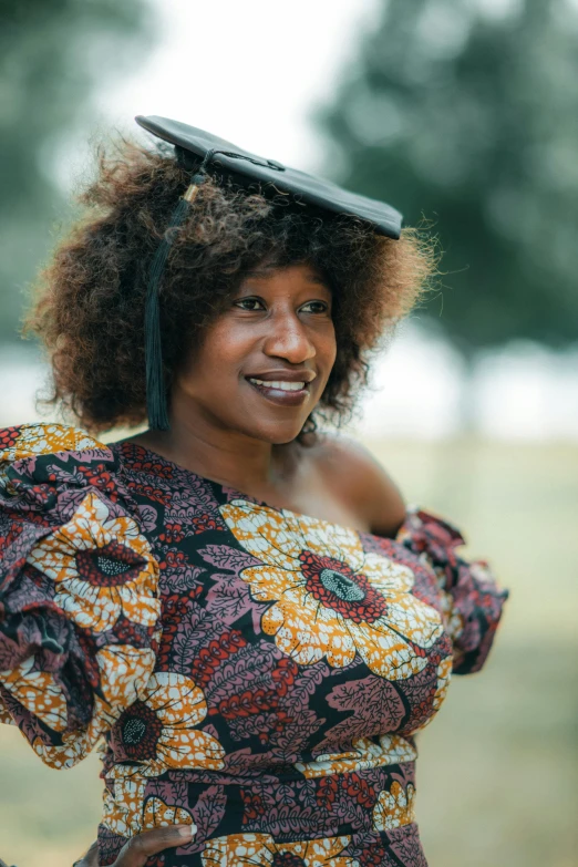 a woman with short brown hair and a hat smiling