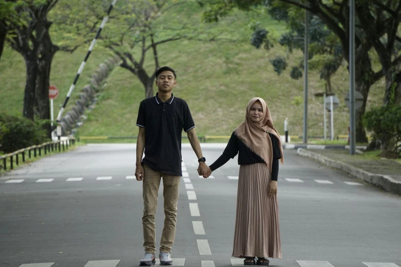 an asian couple standing on a road holding hands