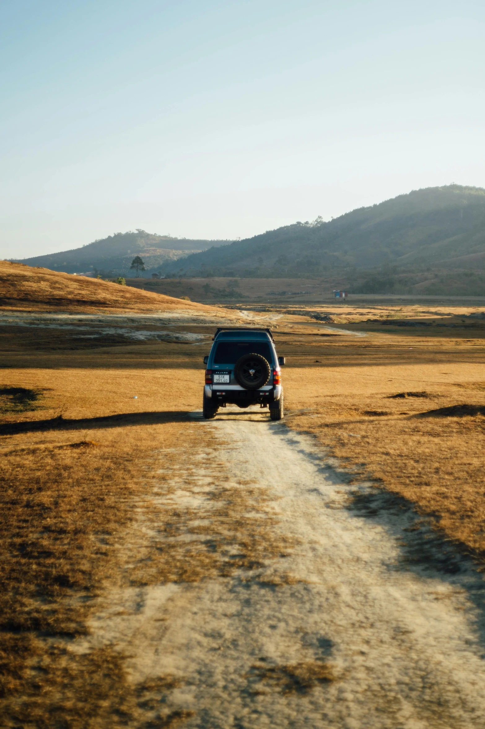 a black vehicle parked on a dirt road