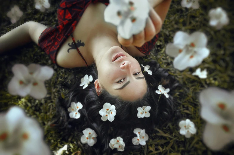 a woman with her eyes closed and flowers scattered around