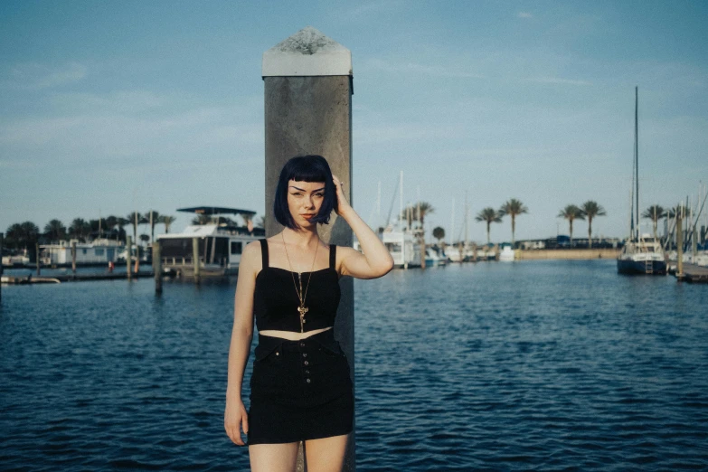 a woman in black outfit standing on dock