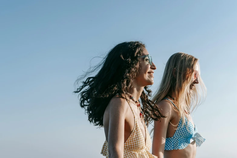 two girls standing by the water with sunburns on their heads