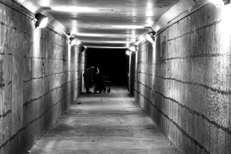 a man and a child are walking through a dark tunnel