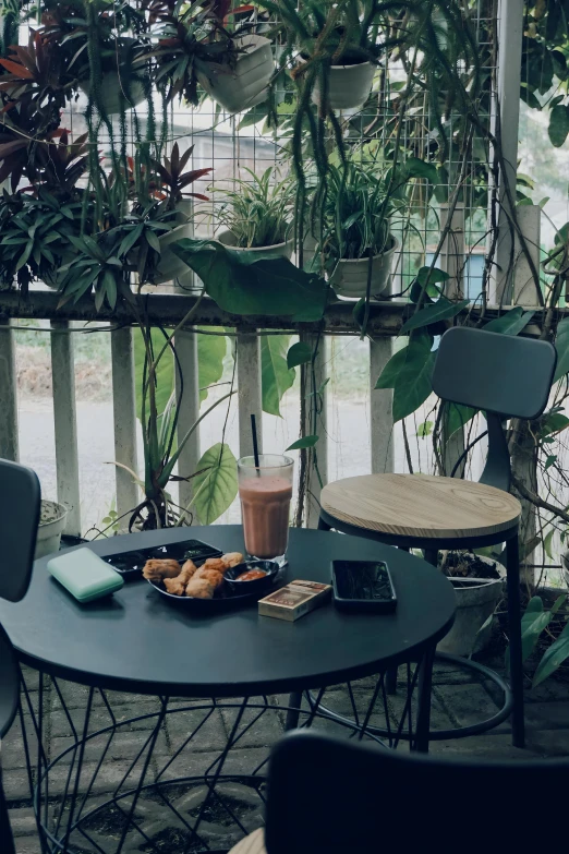 a table is sitting on a balcony with drinks and snacks