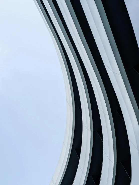 an airplane flying past a tall white and black building