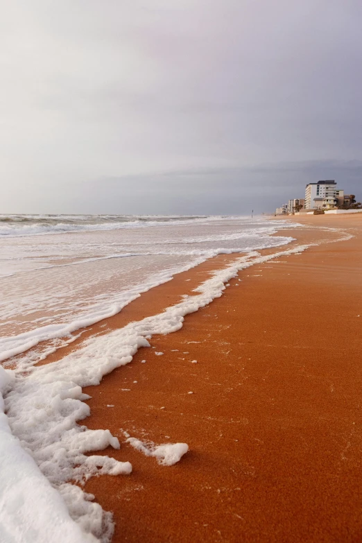 a beach covered with some water next to the ocean