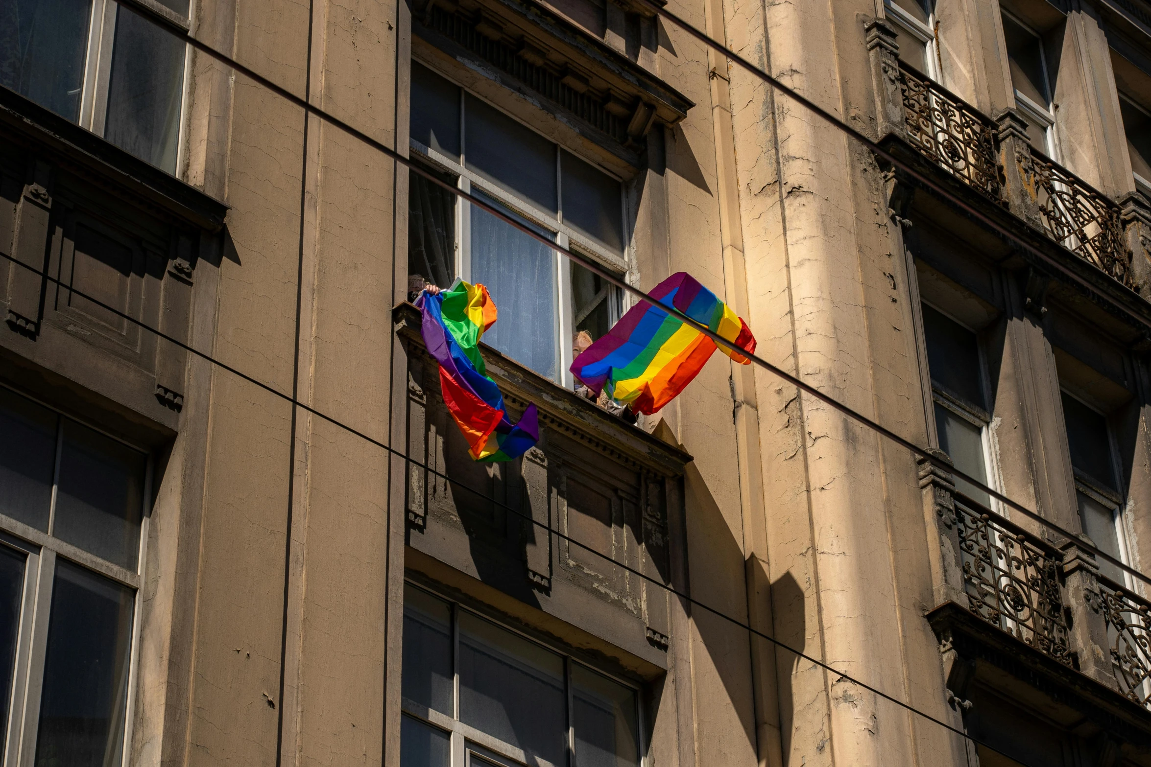 the multi - colored kite hanging on the side of the building is visible