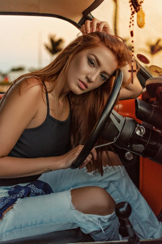 woman with red hair sits in the driver seat of a truck